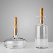 two clear glass bottles with wooden tops on a table