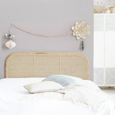 a white bed sitting next to a wall with decorative items on it's headboard