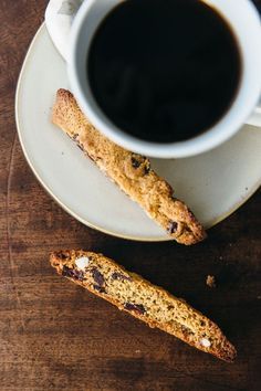 a cup of coffee and two biscuits on a saucer next to it