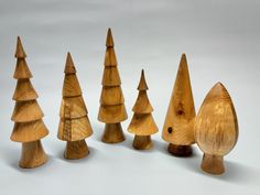 several wooden trees are lined up on a white surface with one standing out from the others