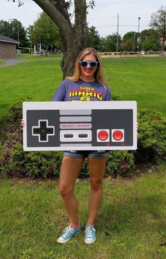 a woman holding up a nintendo game controller costume