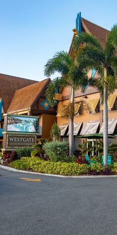 a building with palm trees in front of it and a sign that says westgate