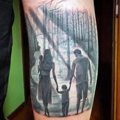 a man with a family tattoo on his leg holding hands and walking in the woods