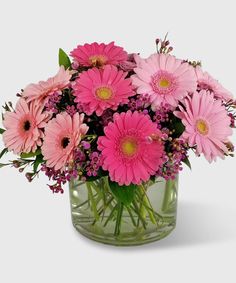 a vase filled with pink flowers on top of a table