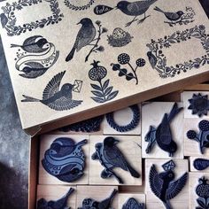 a box filled with lots of different types of wooden magnets on top of a table