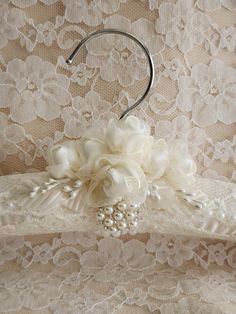 a bridal dress belt with flowers and pearls attached to the belt, along with an umbrella hook