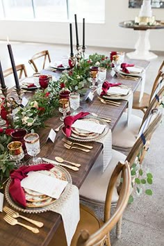 a long table set with place settings and flowers on it for an elegant dinner party