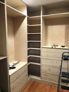 an empty walk in closet with drawers and shelves