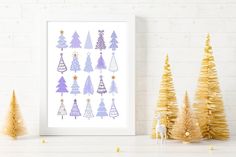 christmas trees are arranged in purple and gold on a white wall next to some small pine trees