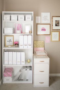 a white book shelf filled with lots of boxes and drawers next to a wall covered in pictures