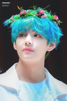 a young man with blue hair wearing a flower crown on top of his head and looking off to the side