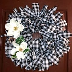 a black and white checkered wreath with flowers on the front door, ready to be decorated