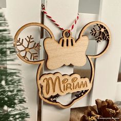 a mickey mouse ornament hanging on a door with a christmas tree in the background