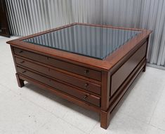 a coffee table with drawers and glass top