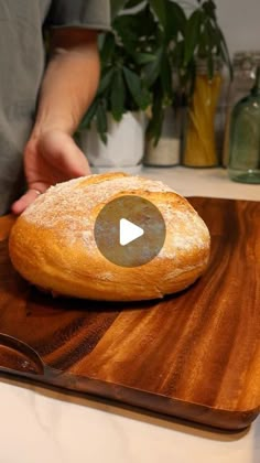 a loaf of bread sitting on top of a wooden cutting board