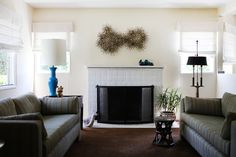 a living room with two couches and a fire place in the middle of it