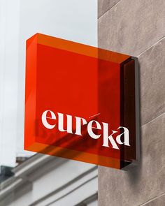 a red sign that says eureka hanging from the side of a building