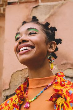 a woman with green and yellow makeup smiling