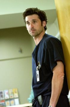 a man in scrubs standing next to a wall