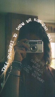 a woman taking a selfie in front of a mirror with words written on it