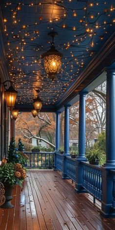 a porch covered in lights and potted plants on the front porch with blue pillars