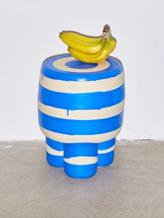 a banana sitting on top of a blue and white striped object in the shape of an elephant