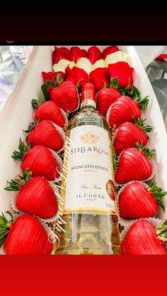 a bottle of wine sitting on top of strawberries