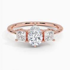 a rose gold engagement ring with three pear shaped diamonds