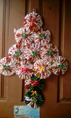 a christmas tree made out of candy canes on the front door with ribbon around it