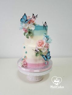 a multi layer cake decorated with flowers and butterflies