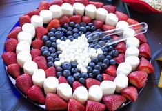 a platter with marshmallows, strawberries and blueberries