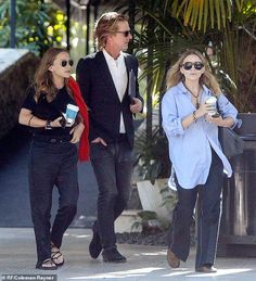 two women and a man walking down the street