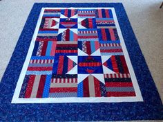 a red, white and blue quilt on the floor