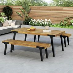 an outdoor table with benches and potted plants