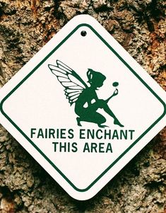 a sign that says fairies enchant this area on the side of a tree