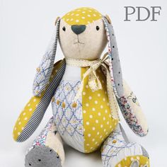 the stuffed animal is yellow and white with polka dots on it's face, sitting in front of a white background