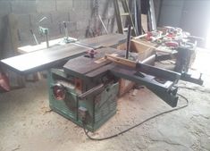 a table sawing machine sitting on top of a piece of wood in a room