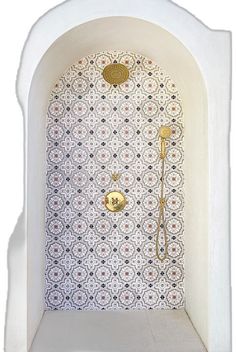 a white and gold tiled shower in a bathroom with an ornate wallpapered design