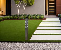 a modern house with grass and stepping stones leading to the front door is seen in this photograph