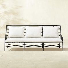 a black and white couch sitting on top of a tile floor next to a wall