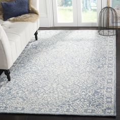 a living room with a white couch and blue rug