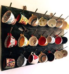 there are many cups hanging on the wall