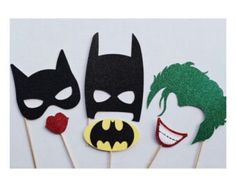 three batman masks are on top of toothpicks with red lips and green hair