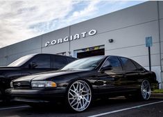 two black cars parked in front of a building