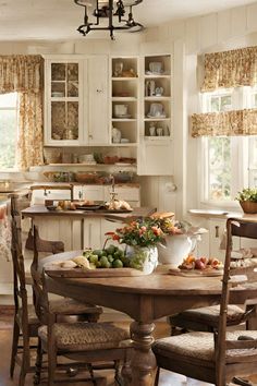 a kitchen with a table, chairs and cupboards filled with food on top of it