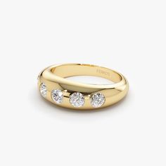 a yellow gold ring with five diamonds on the inside and outside, set against a white background