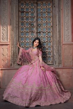 a woman in a pink gown posing for the camera