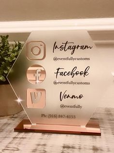 a glass plaque with the words facebook and love on it sitting next to a potted plant