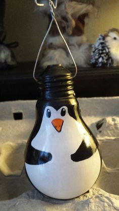 a black and white penguin light hanging from a wire