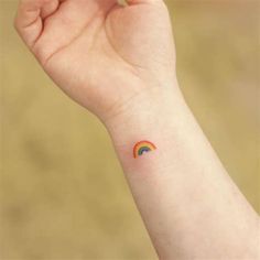 a small rainbow tattoo on the wrist